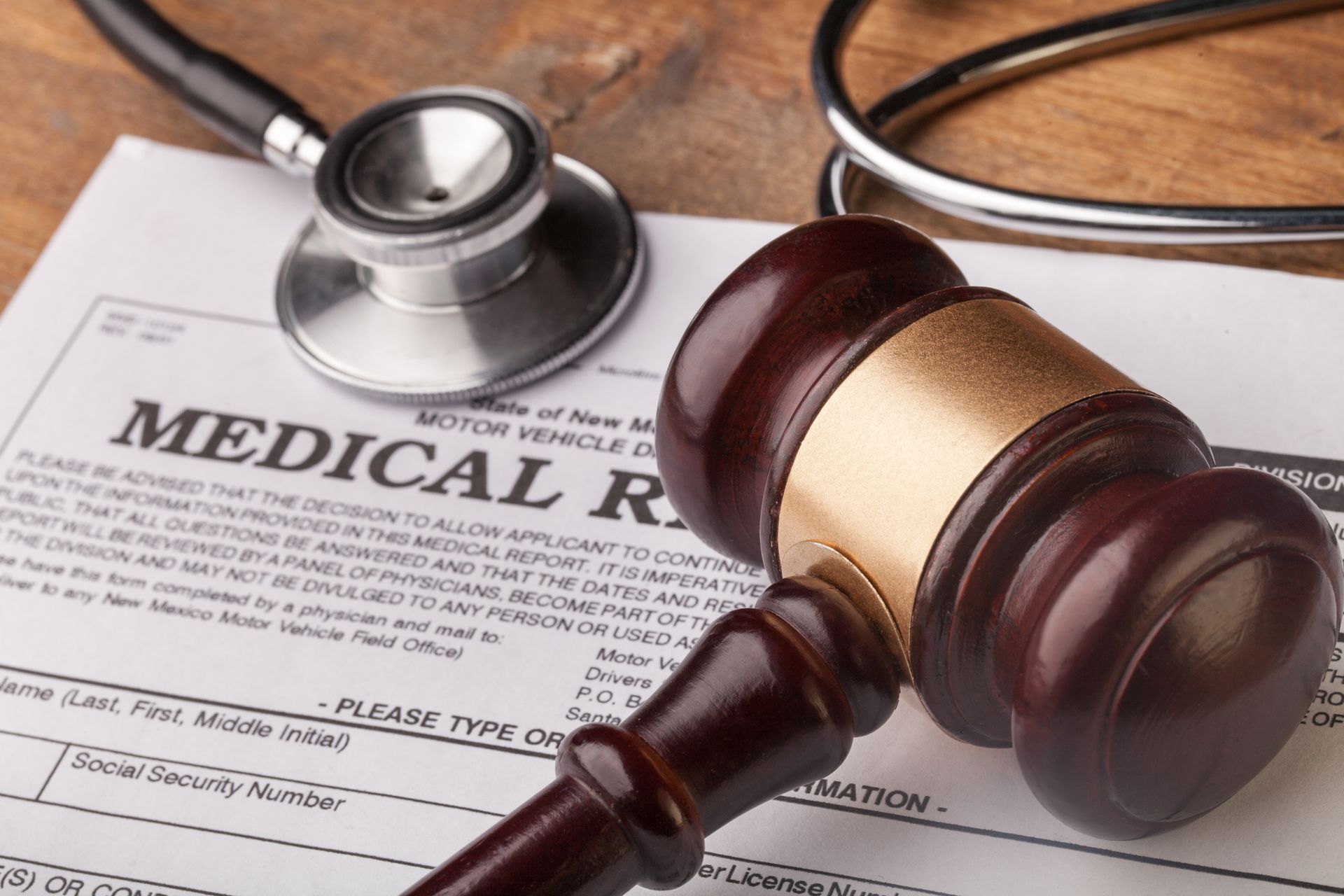 Wooden gavel and stethoscope on medical record sheet