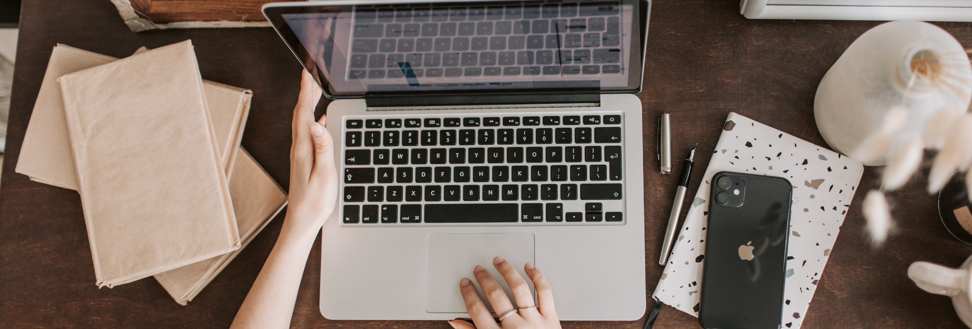 A person is typing on a laptop computer at a desk.