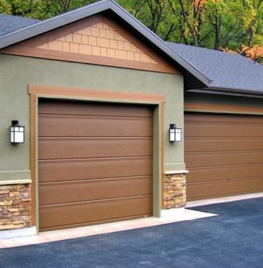 Brown garage doors on a house with tan and stone accents.