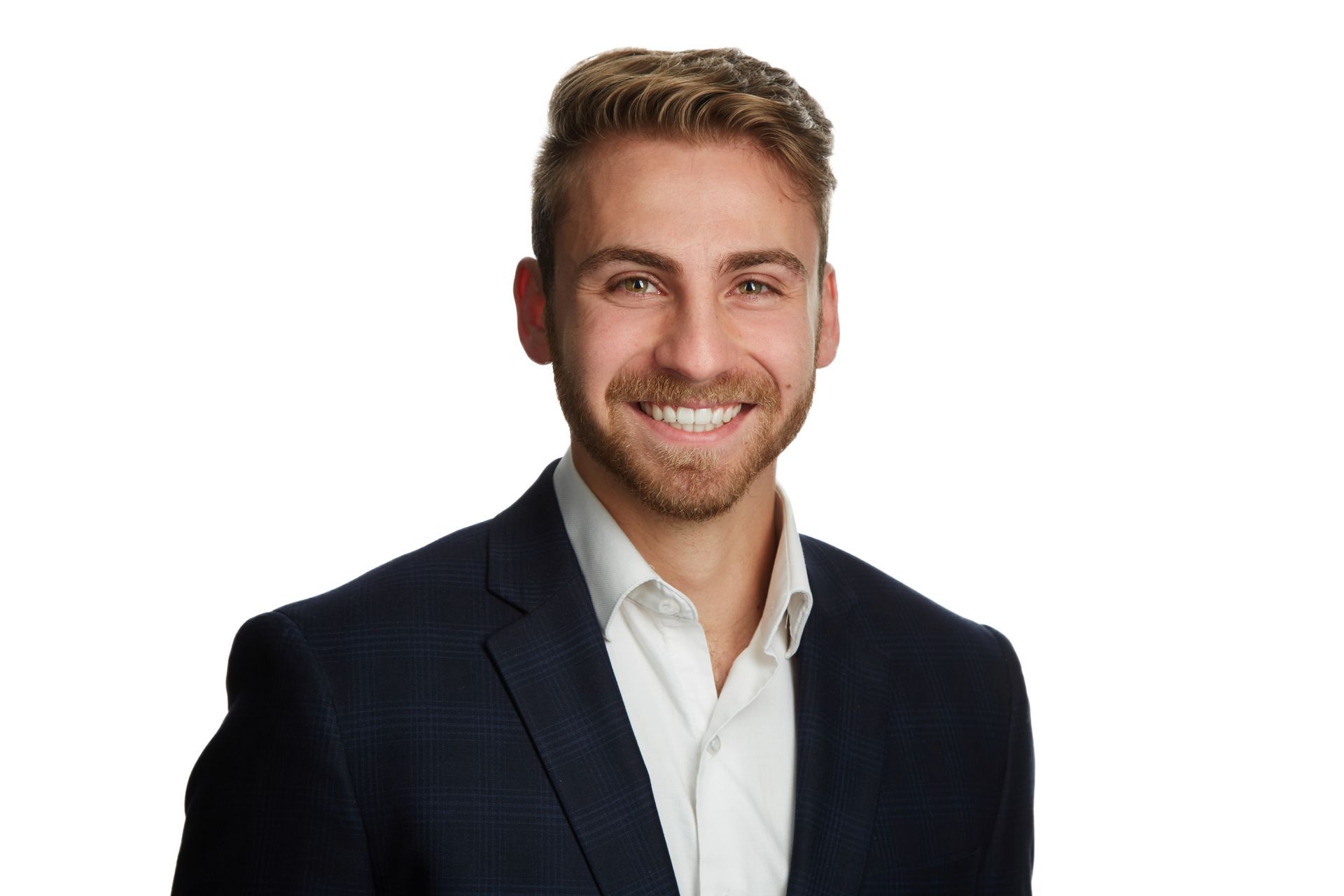 A man in a suit and white shirt is smiling for the camera.