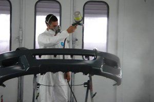 Technician applying auto body paint in Buffalo, NY