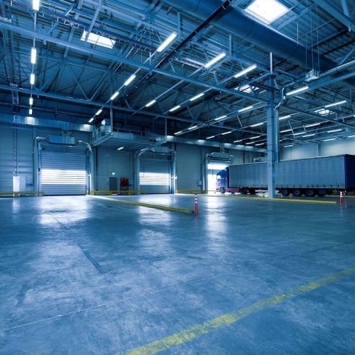 A large warehouse with a lot of trucks in it