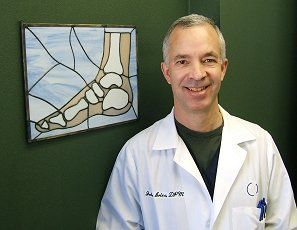 Podiatrist — Dr. Ariza Smiling with the Foot Picture in his Side in Reno, NV