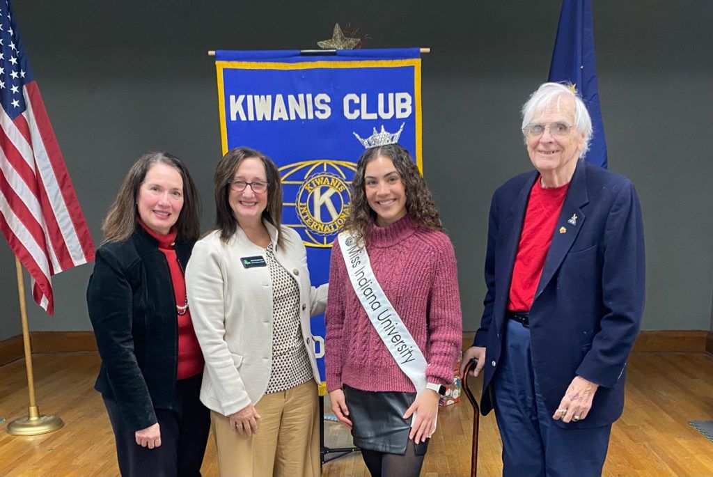 Diana Fellure, Sheila Klopfenstein, Alexxys Standish, and Allen Pease pose for a photo in front of the Kiwanis Club of Bloomington banner.