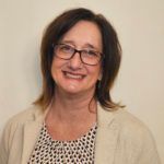 Woman with glasses is smiling.