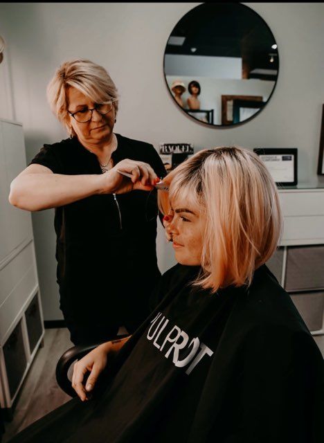 The back of a woman with red and purple hair.