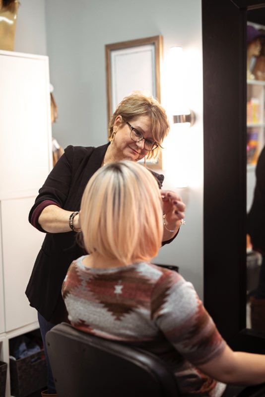 A woman is getting her hair examined by a hairdresser.