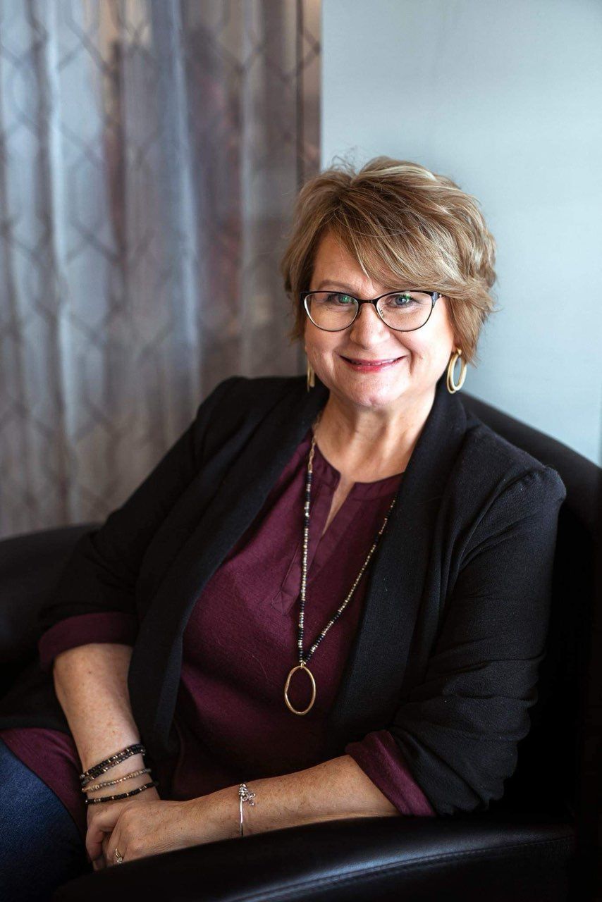 A woman is holding a wig in her hands.
