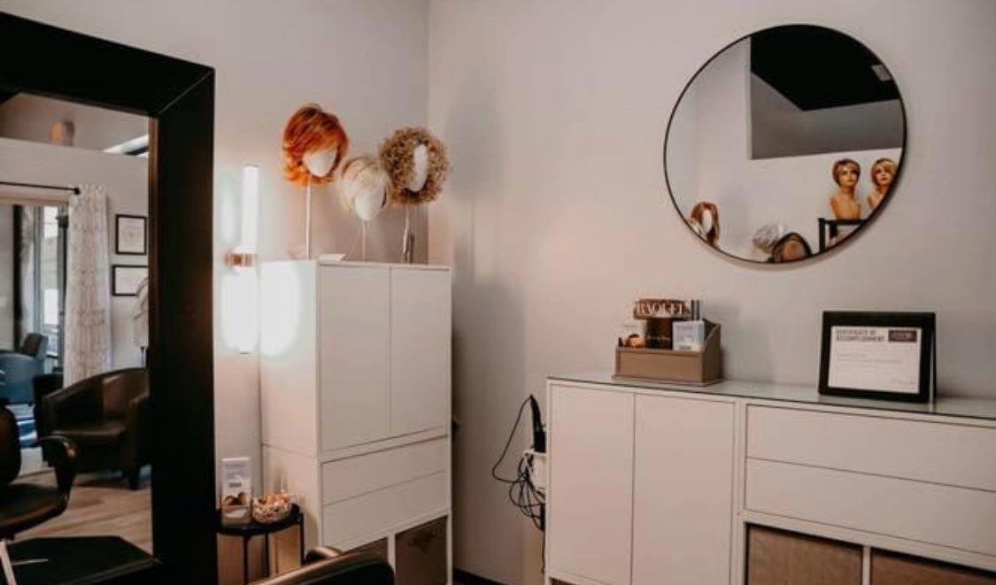 A woman with gray and purple hair is wearing a wig.