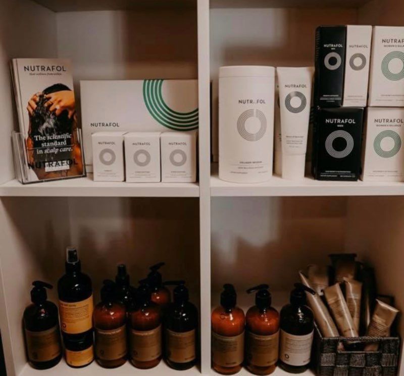 A row of mannequins wearing wigs in a store.