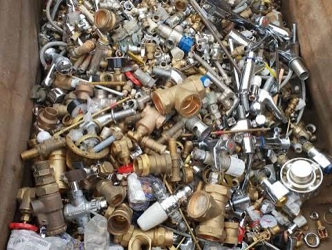 Scrap metal pile of brass and steel plumbing fixtures, fittings, and pipes.