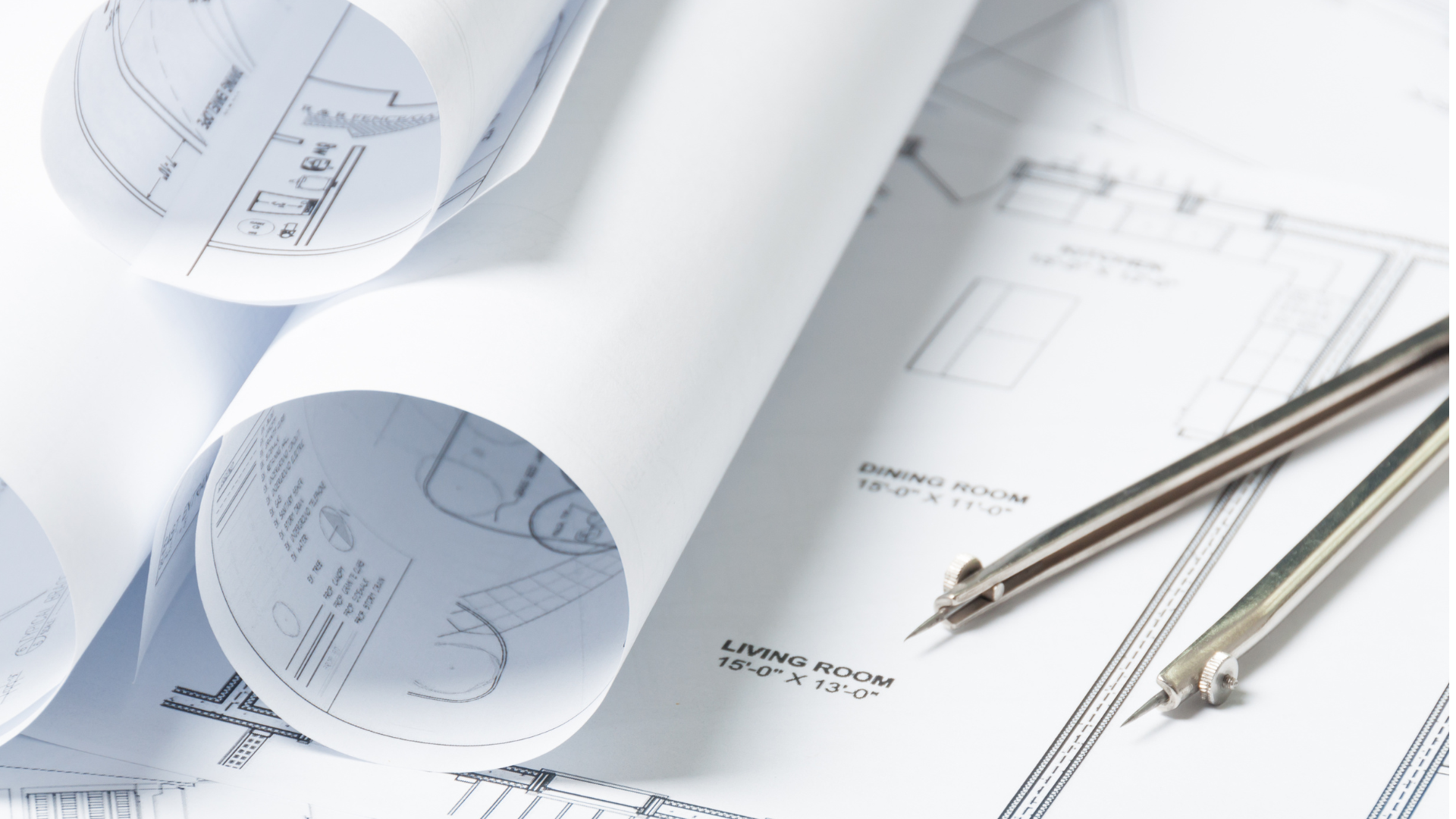 a compass is sitting on top of a stack of blueprints .