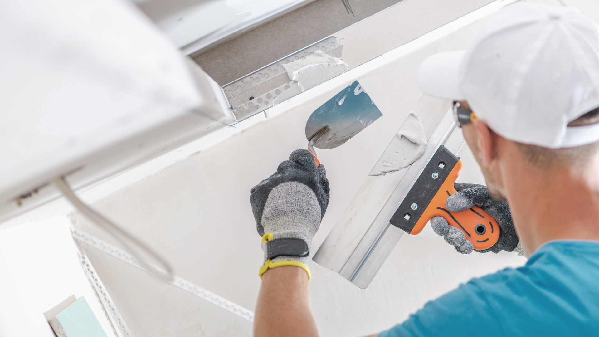 a man is plastering a wall with a trowel .