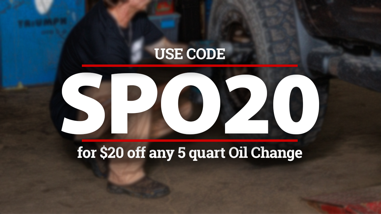 Mechanic changing a tire, coupon code SPO20 for $20 off a 5-quart oil change.