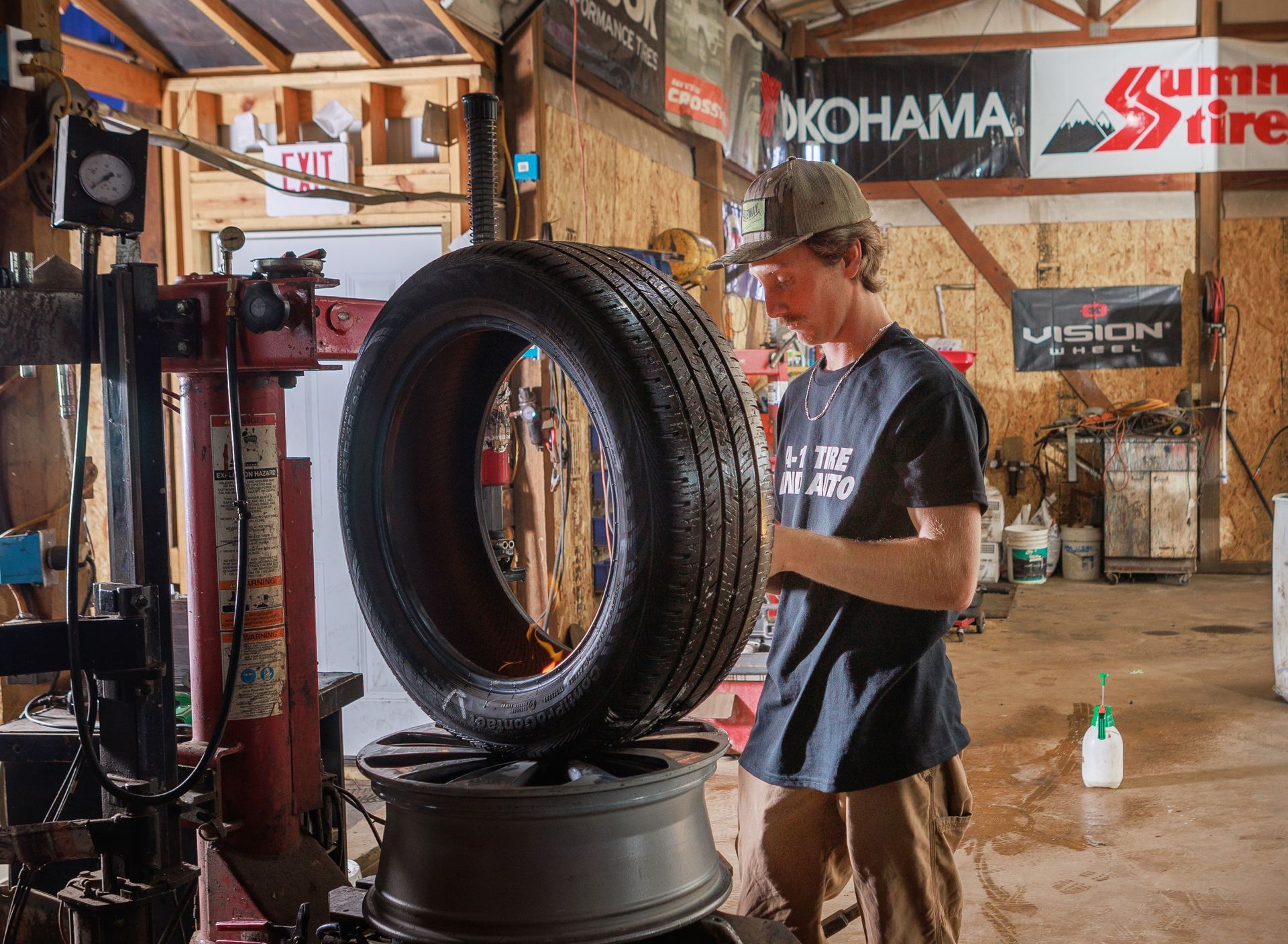 A person mounting a tire on a rim in a garage.