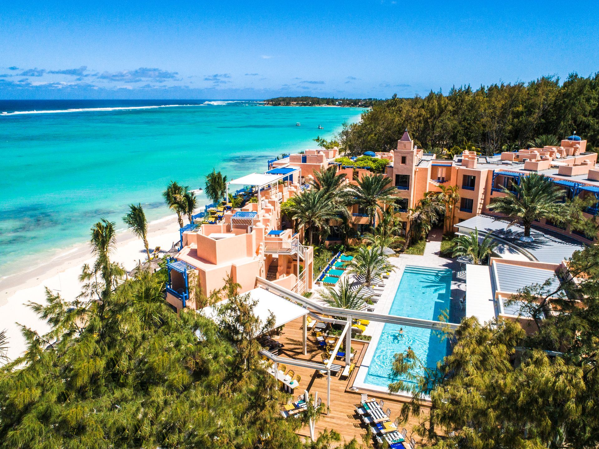 Tropical beachfront of Salt of Palmar  with turquoise ocean, palm trees, and a pool beside sandy shore