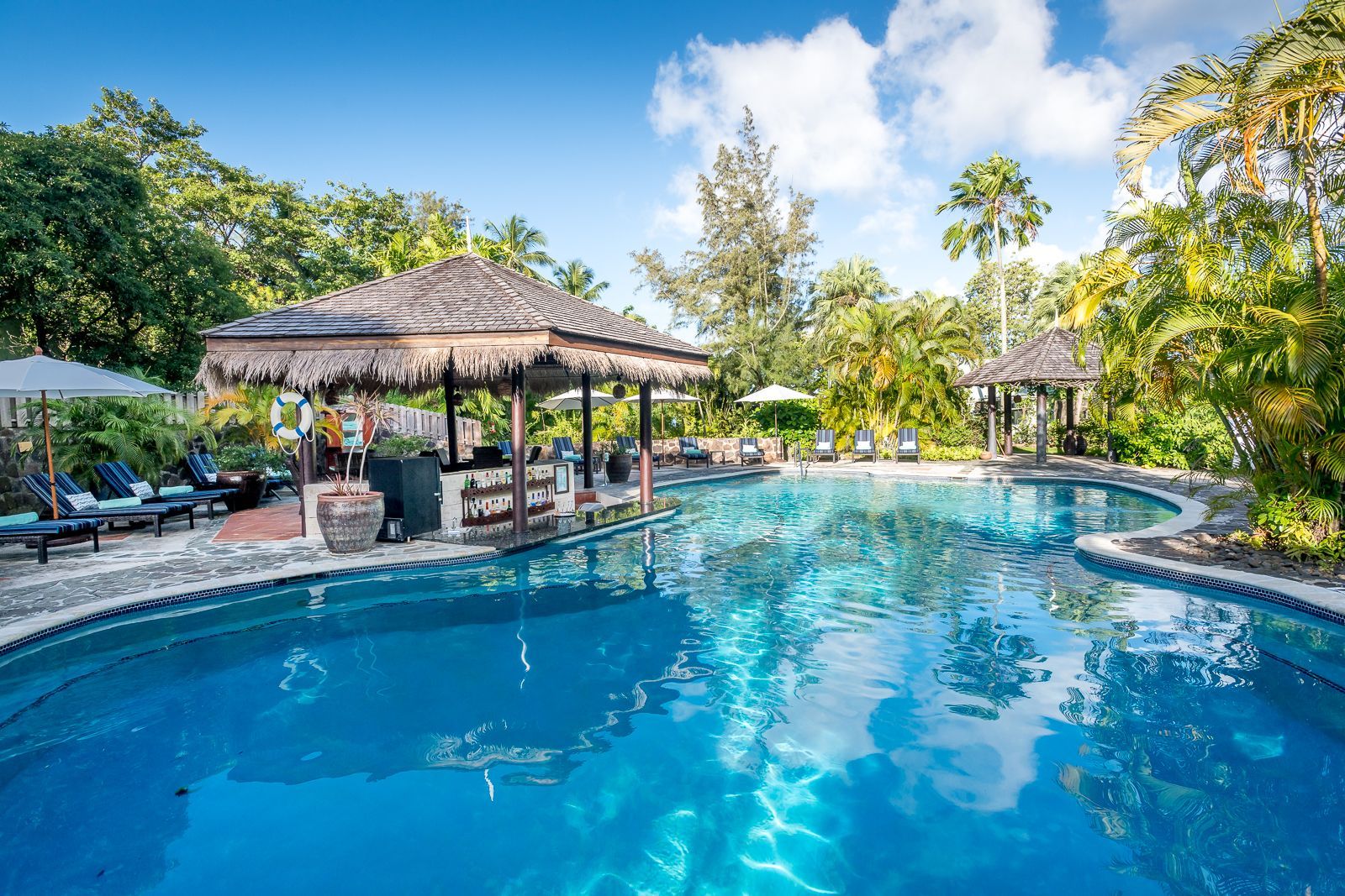 There is a large swimming pool with a bar in the middle of it.