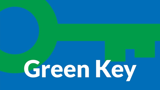 A green key is on a blue background with the words green key below it.