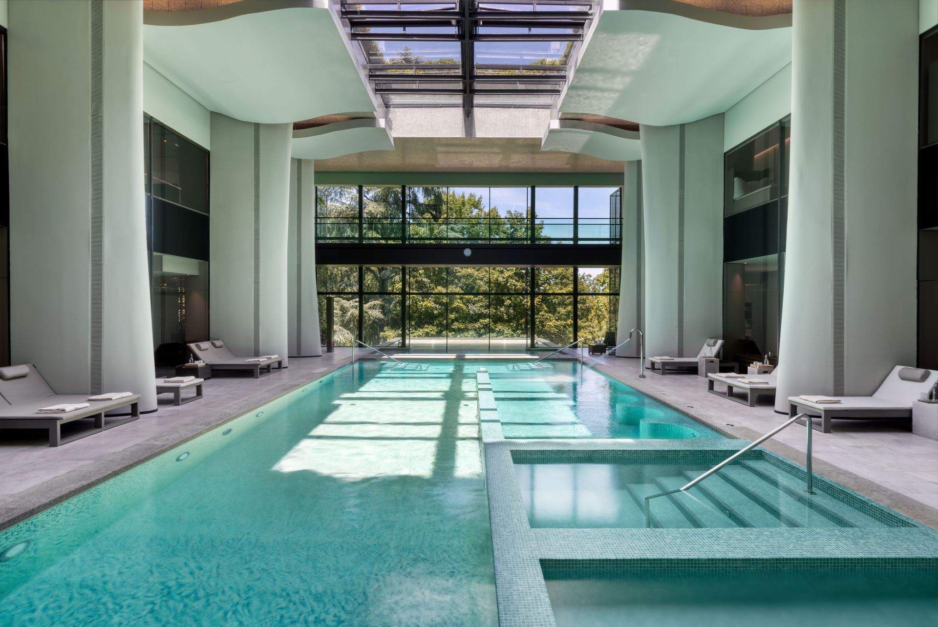 A large indoor swimming pool with stairs leading to it.