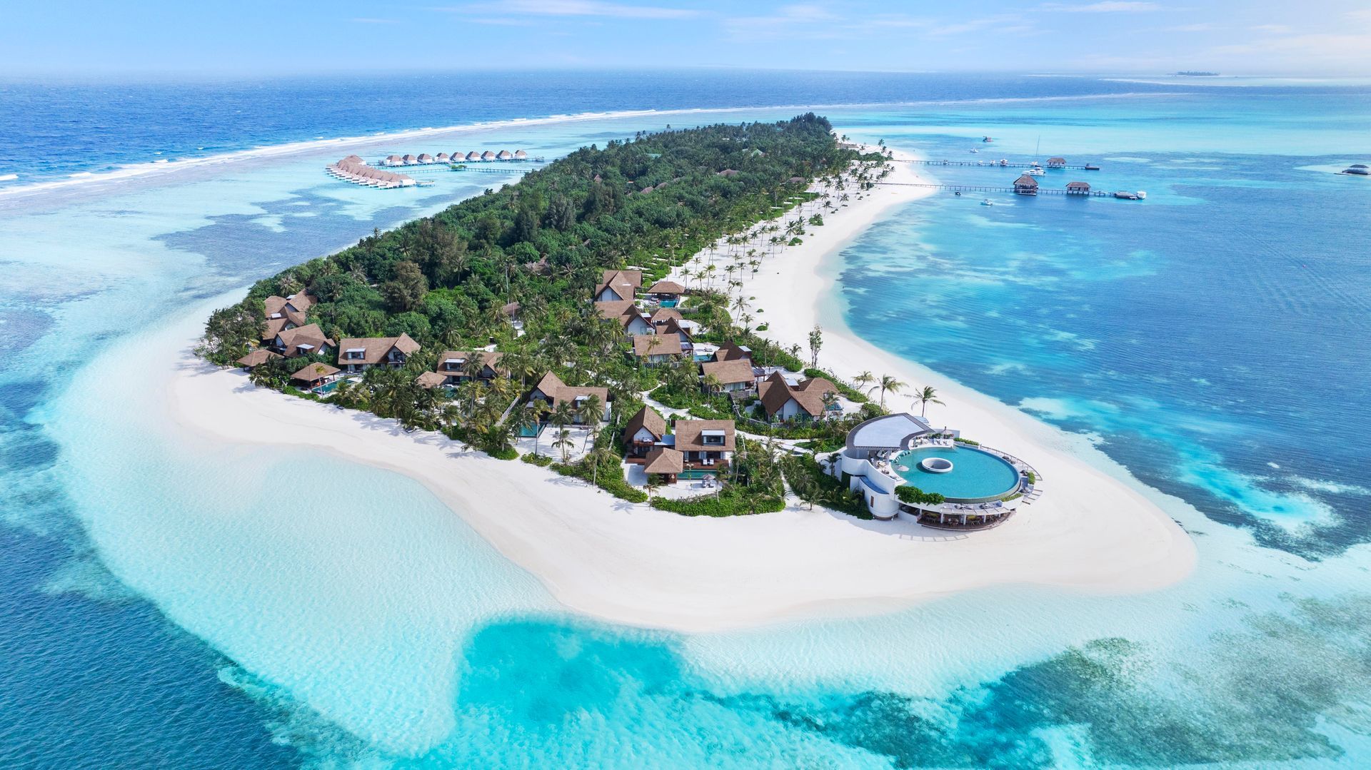 Aerial view of a Six Senses Kanuhura, a sustainable Maldivian island resort with white sand beaches and bright turquoise water.