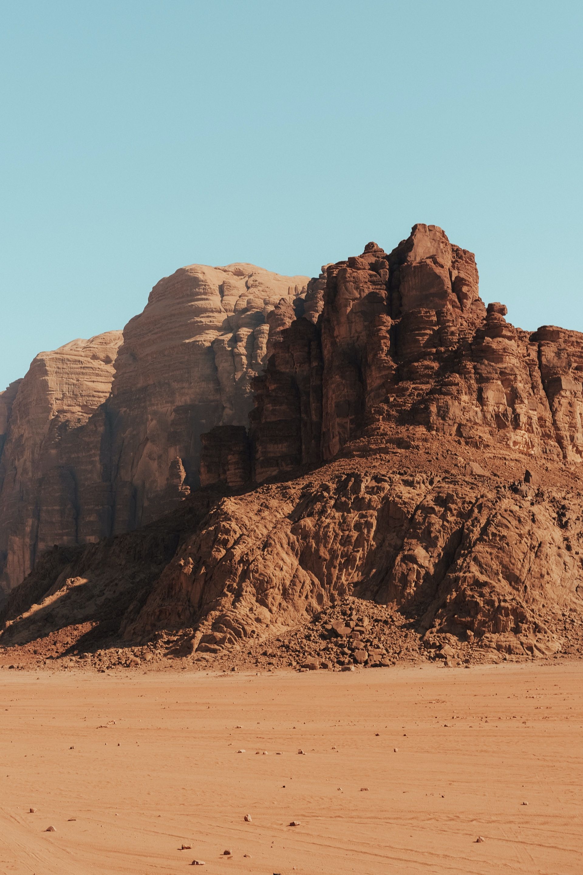 A large rock formation in the middle of a desert.