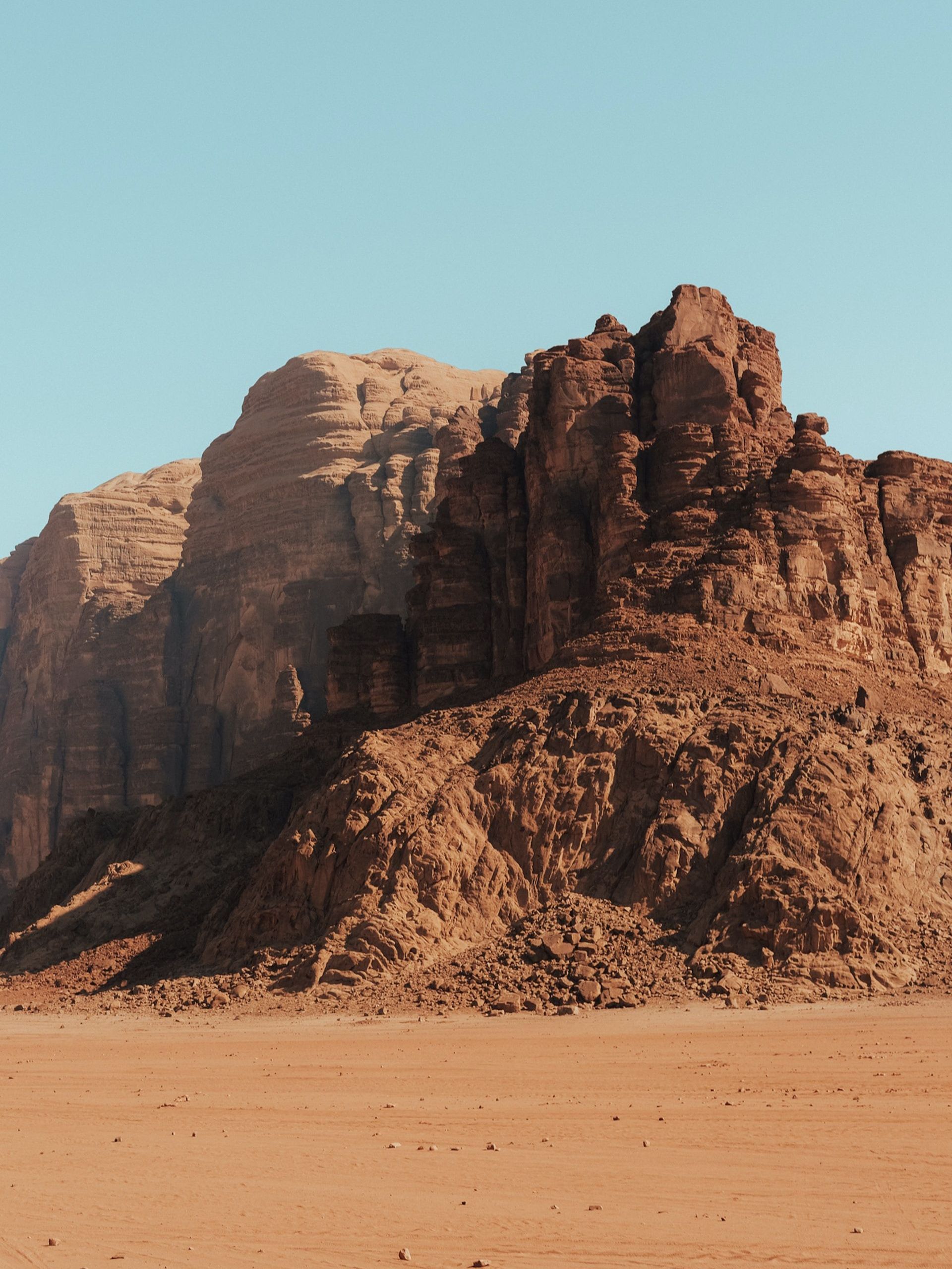 A desert landscape with a mountain in the background