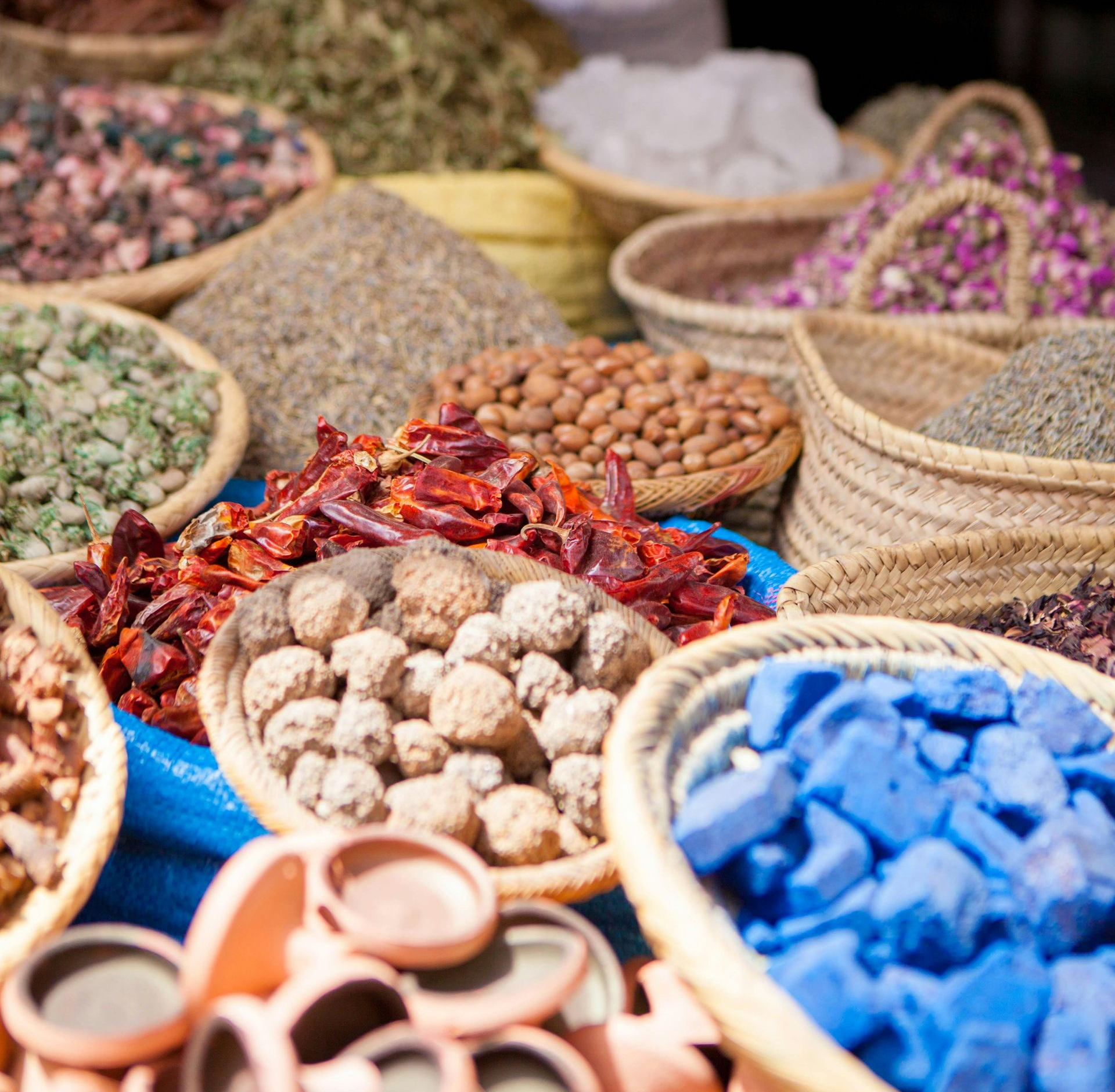 Colorful baskets of dried spices and herbs displayed in a market stall
