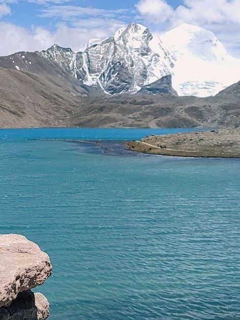 A lake surrounded by mountains with a mountain in the background