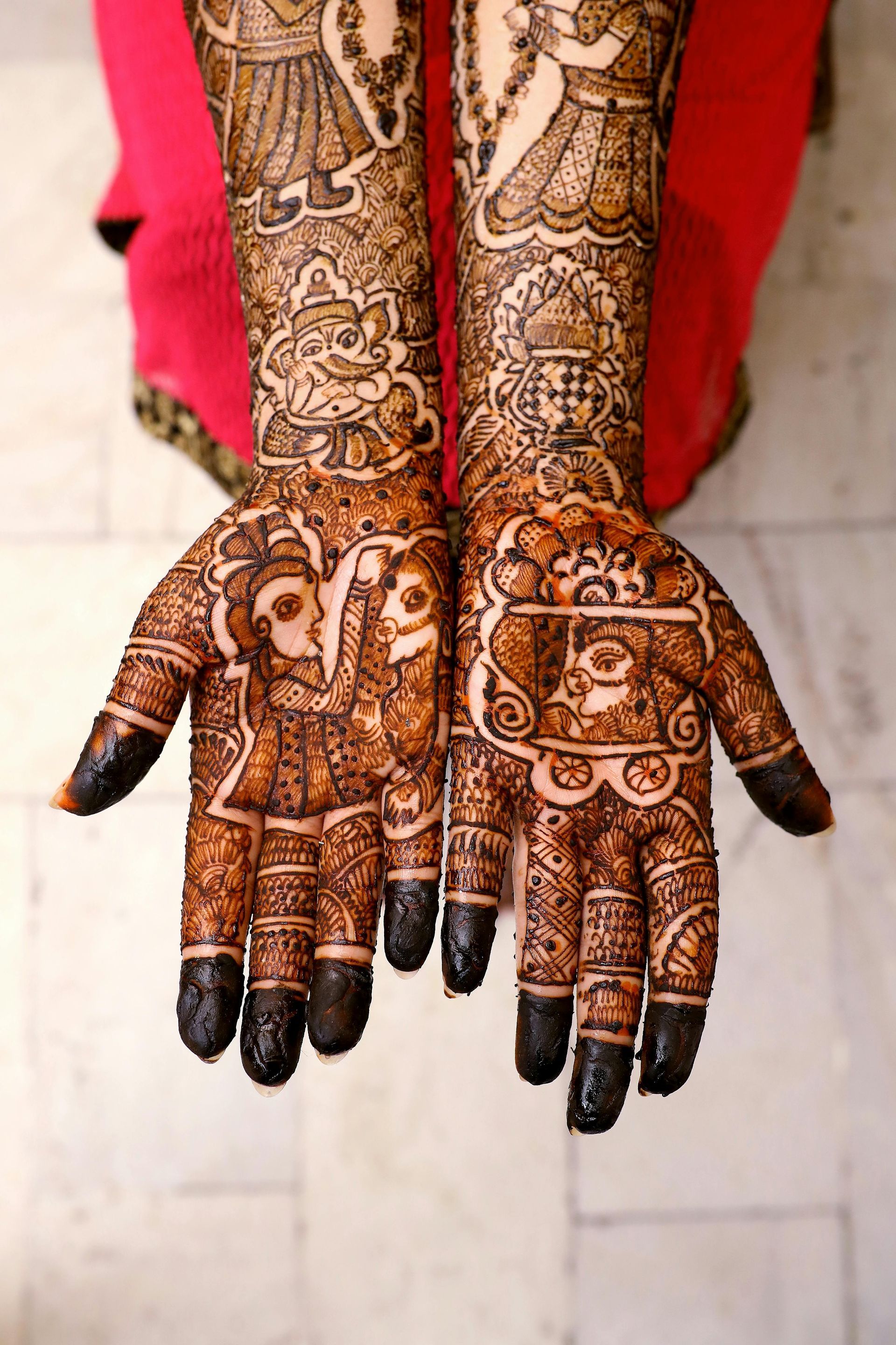 A close up of a woman 's hands with henna on them