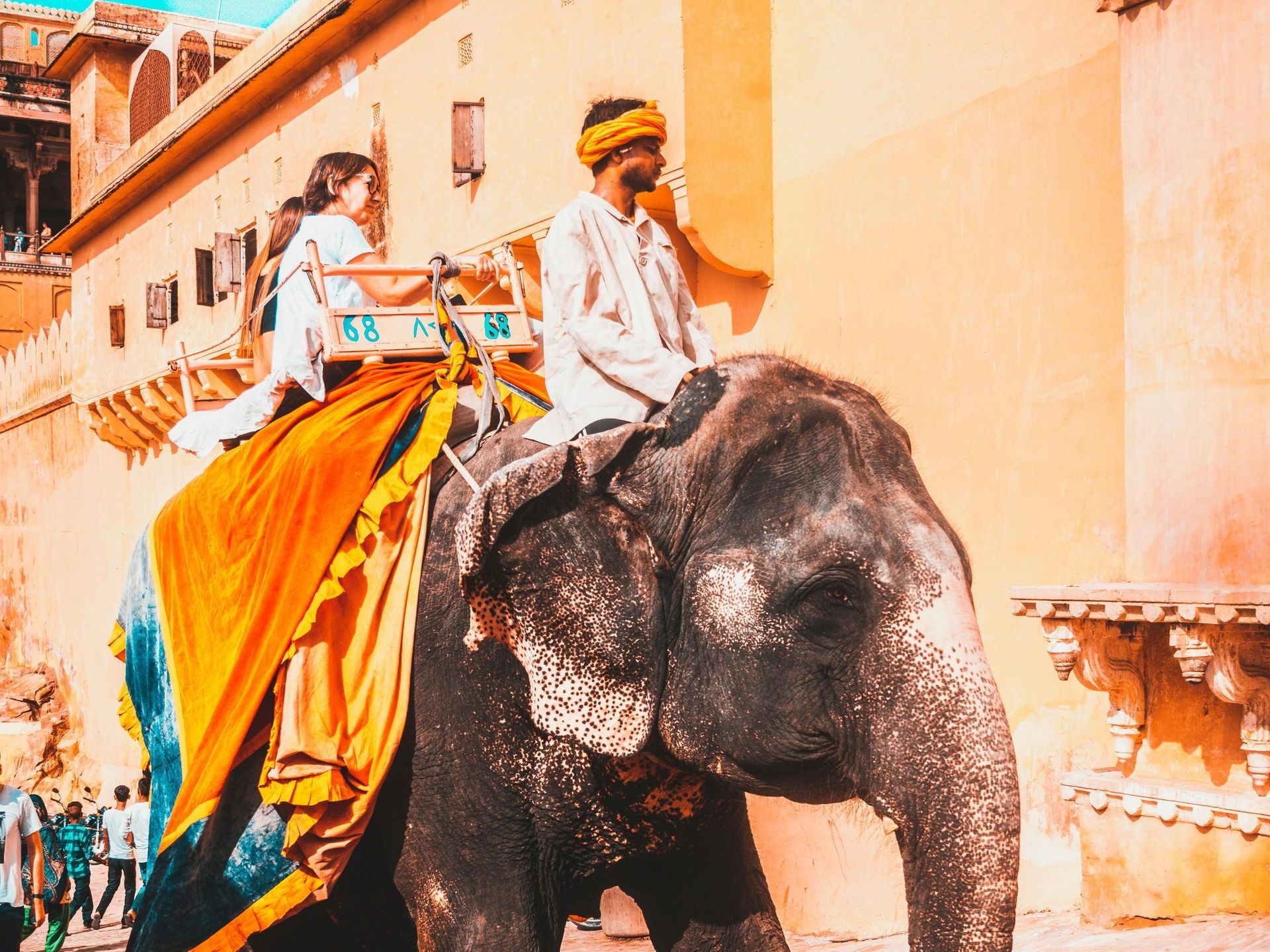 A man and woman are riding on the back of an elephant.