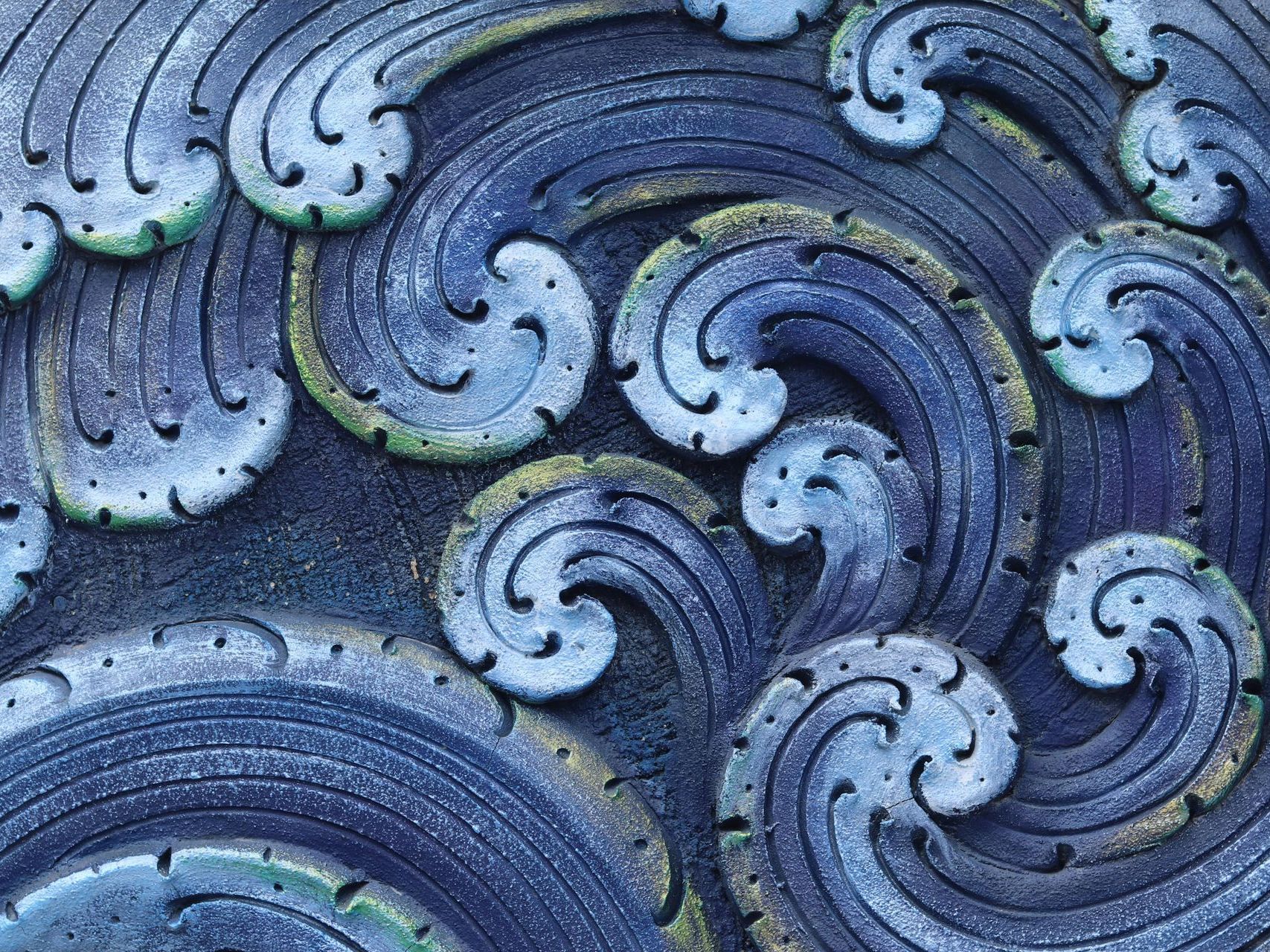 A close up of a painting of waves on a wall.