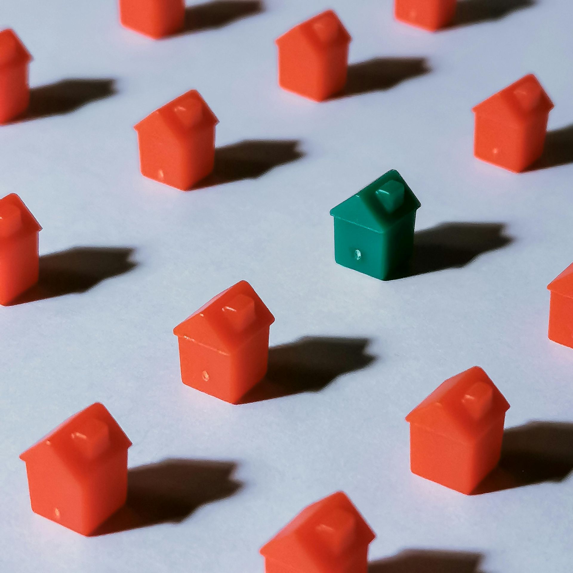 Monopoly Green house stands out among scattered red houses.