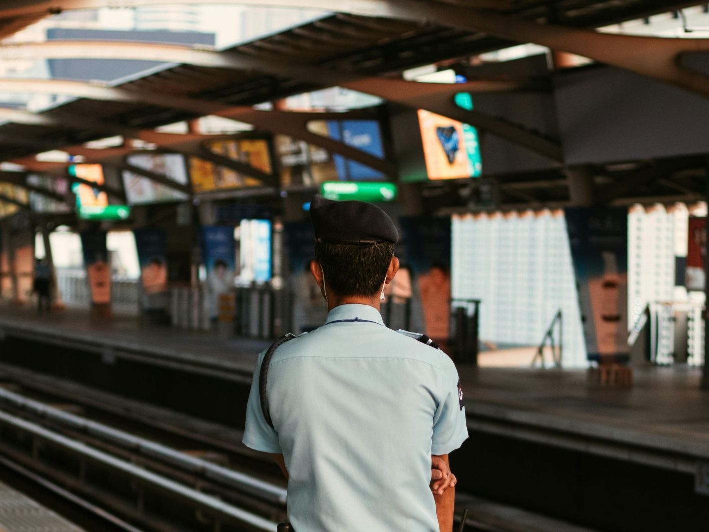 A man in a uniform is standing at a train station