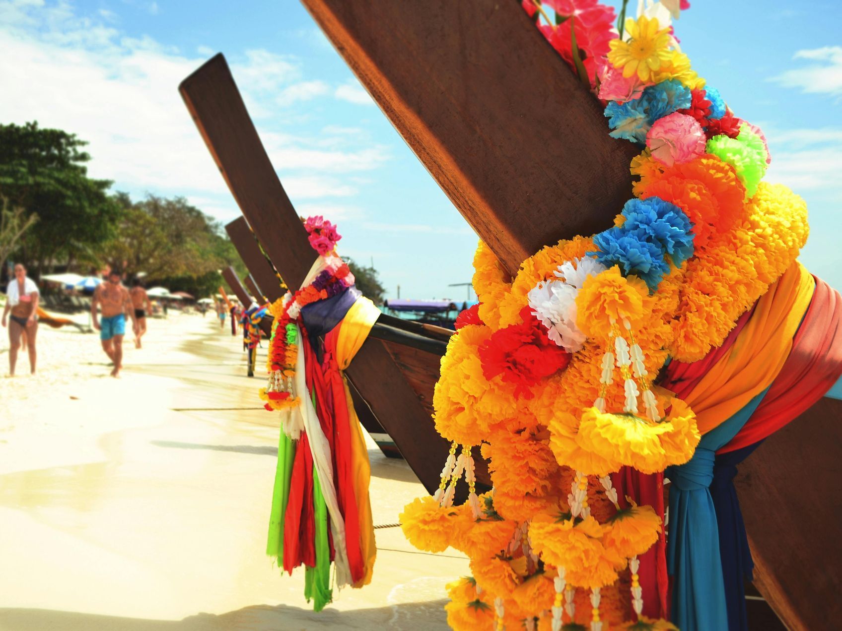 A boat is decorated with flowers and ribbons on the beach