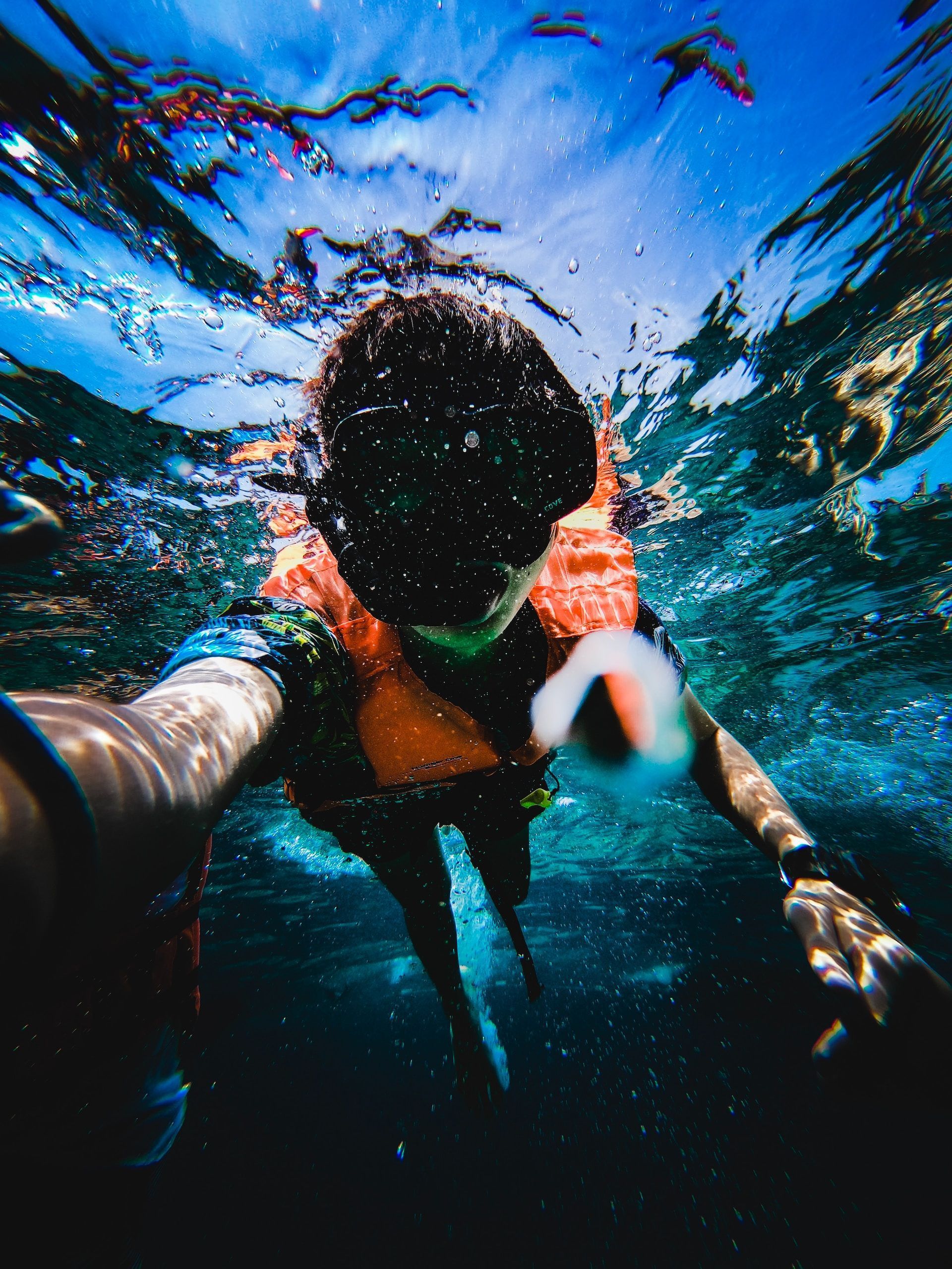 A person is taking a selfie underwater in the ocean.