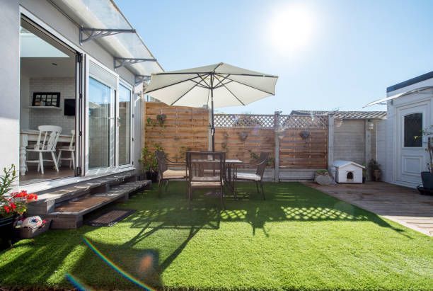 A general view of a small back garden yard patio on a hot sunny day with table and chairs