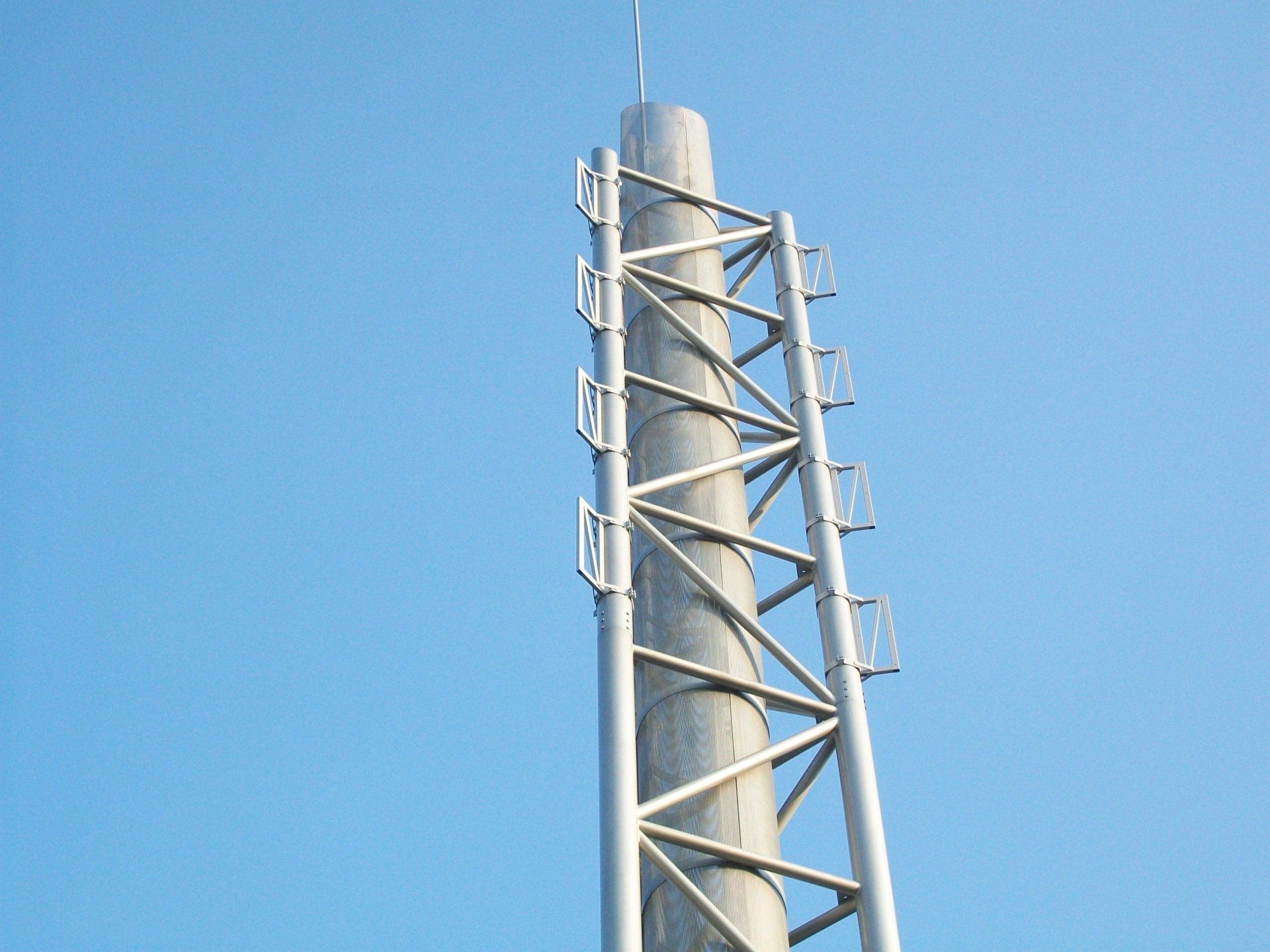 Alta torre di metallo con una scala contro il cielo blu.