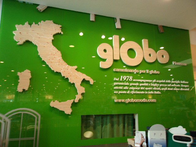 Insegna verde Globo con il profilo dell'Italia sul muro.