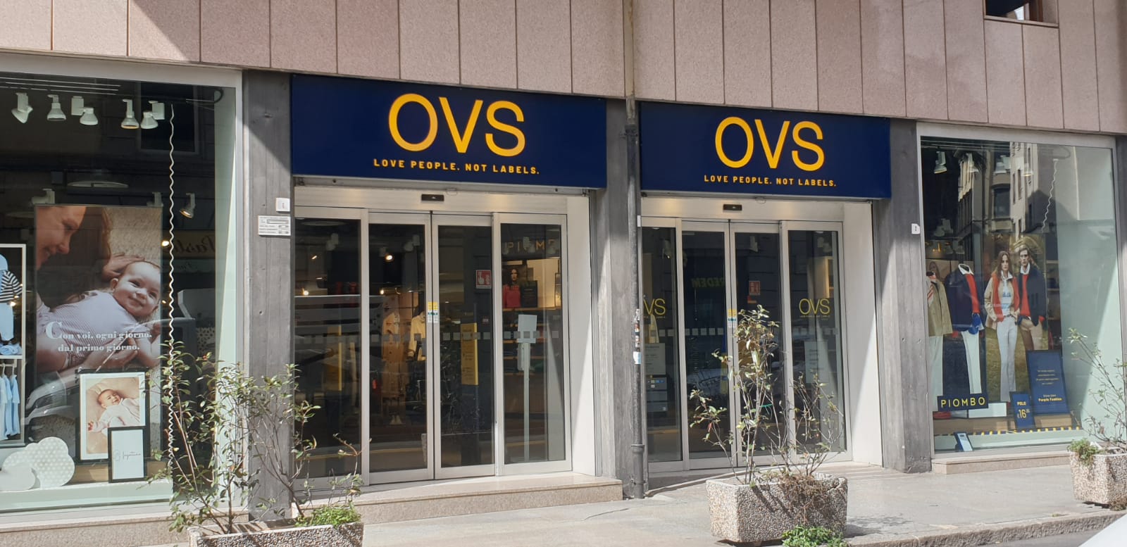 Vetrina del negozio di abbigliamento OVS con porte automatiche e una vetrina su ogni lato.