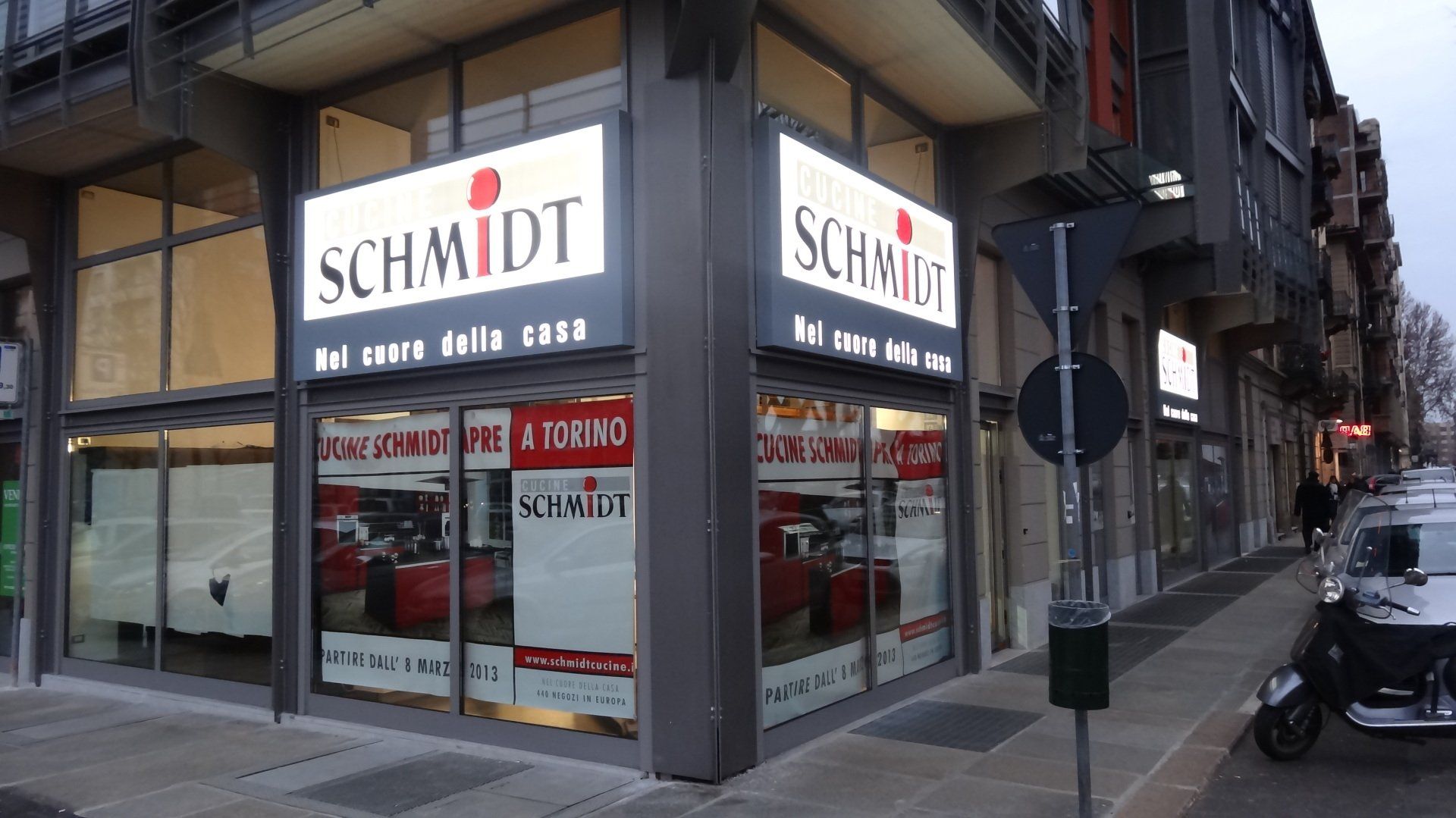 Esterno di un negozio di mobili Schmidt con insegne luminose, vetrine e ambientazione stradale.