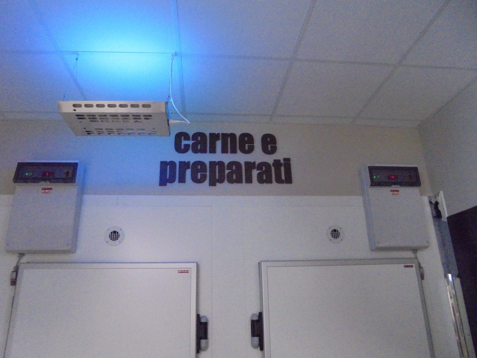 Frigorifero per carne e cibi preparati, testo in italiano, luce blu, porte bianche, pannelli di controllo.
