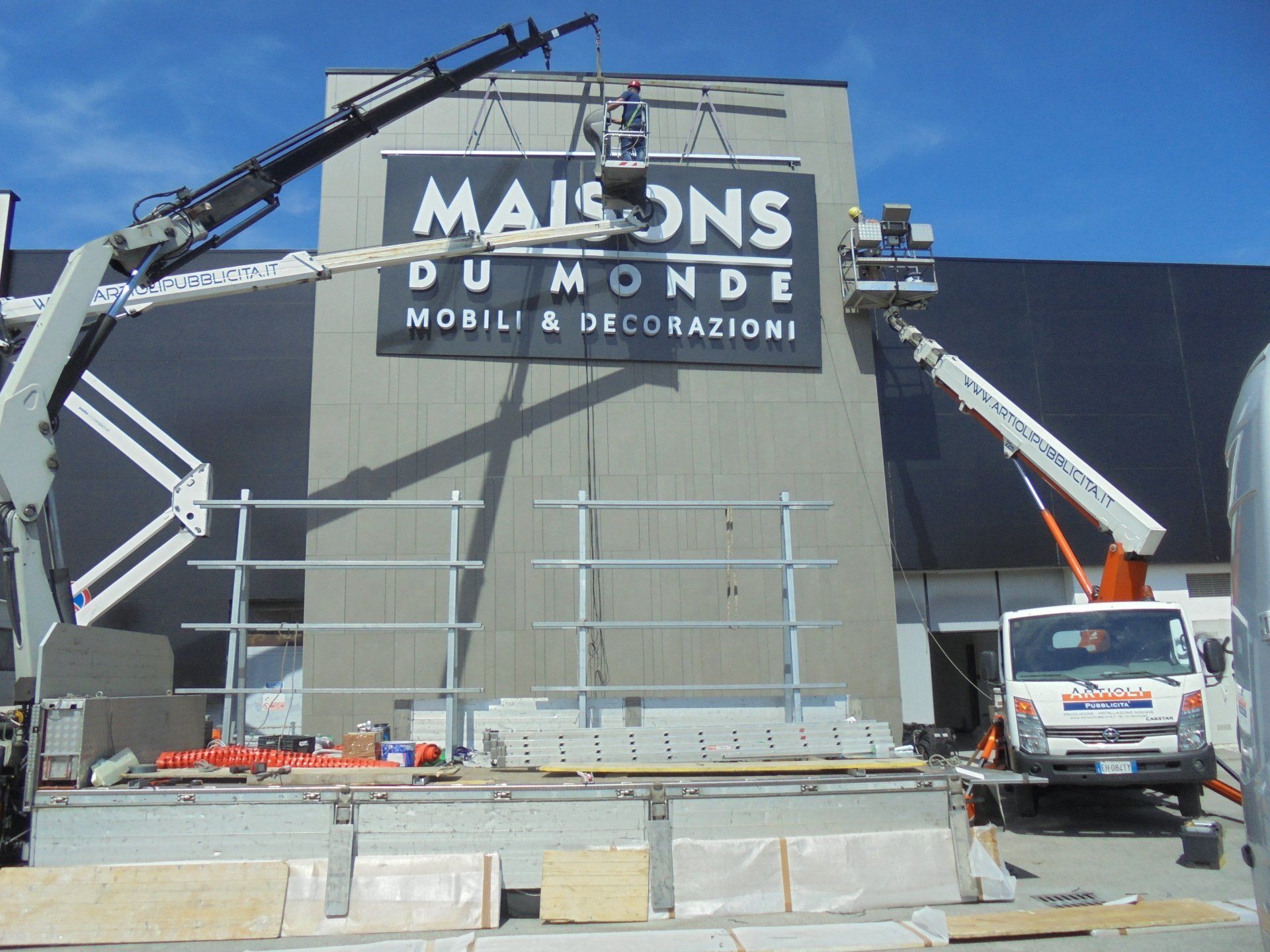 Gru che installano un cartello 