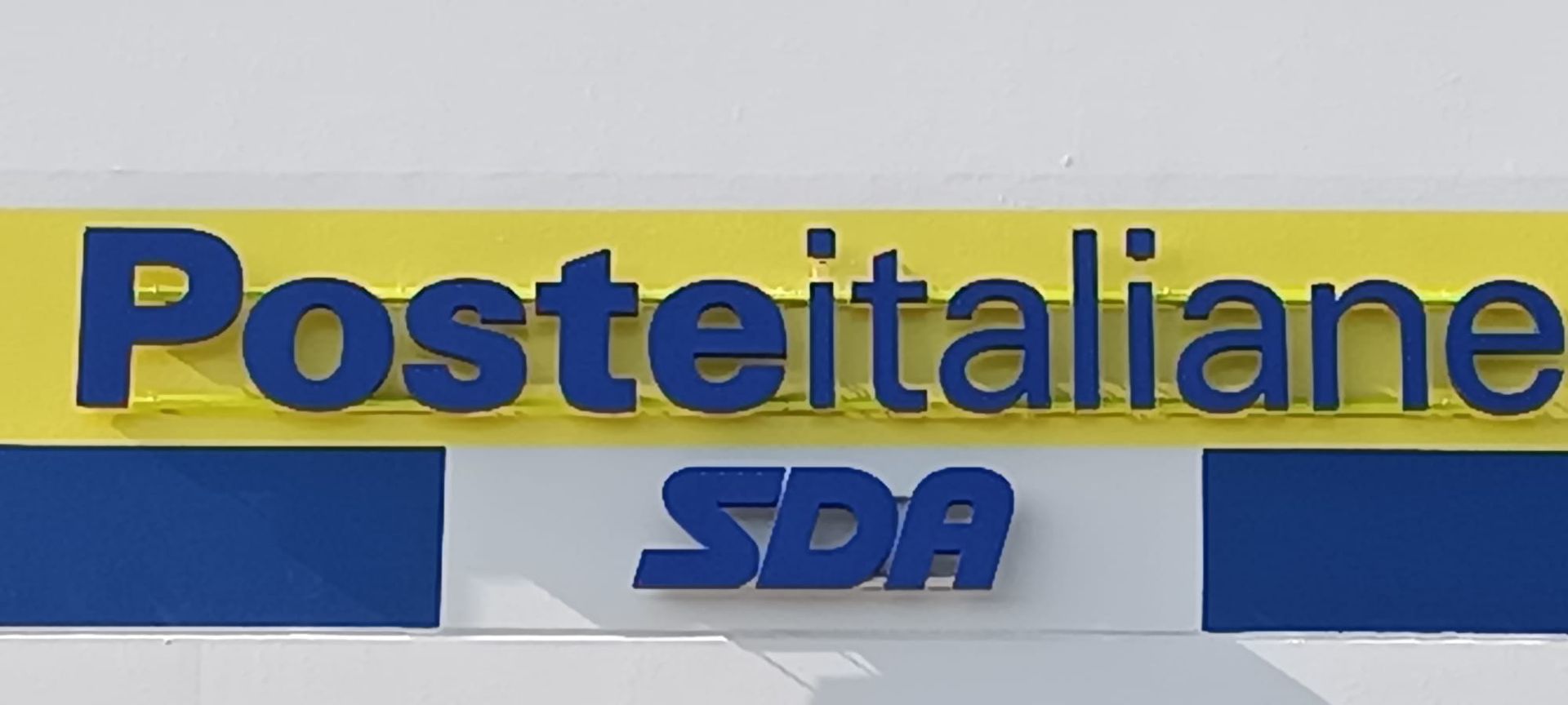 Logo di Poste Italiane e SDA, in testo blu con sfondo giallo su superficie bianca.