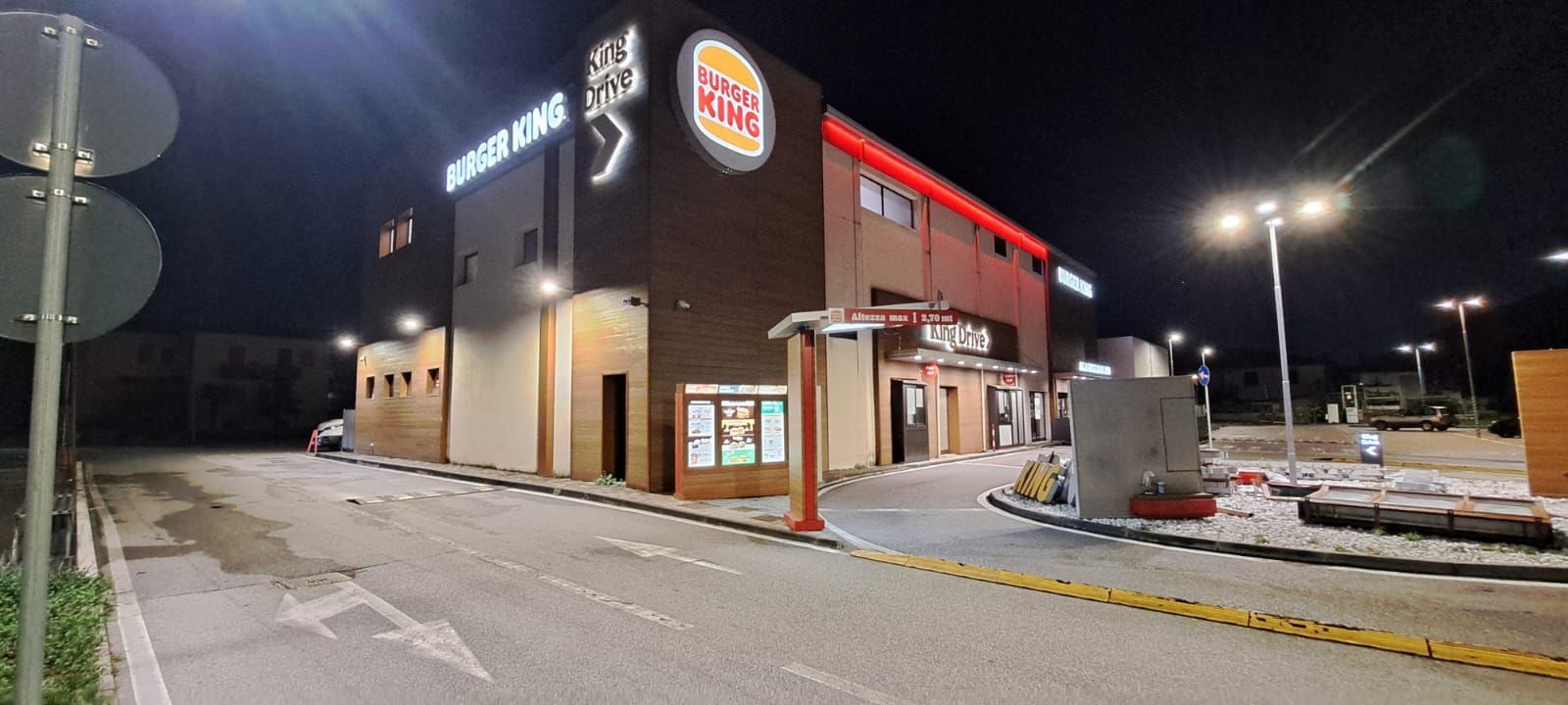 Ristorante Burger King di notte, con corsia drive-through e insegne luminose.