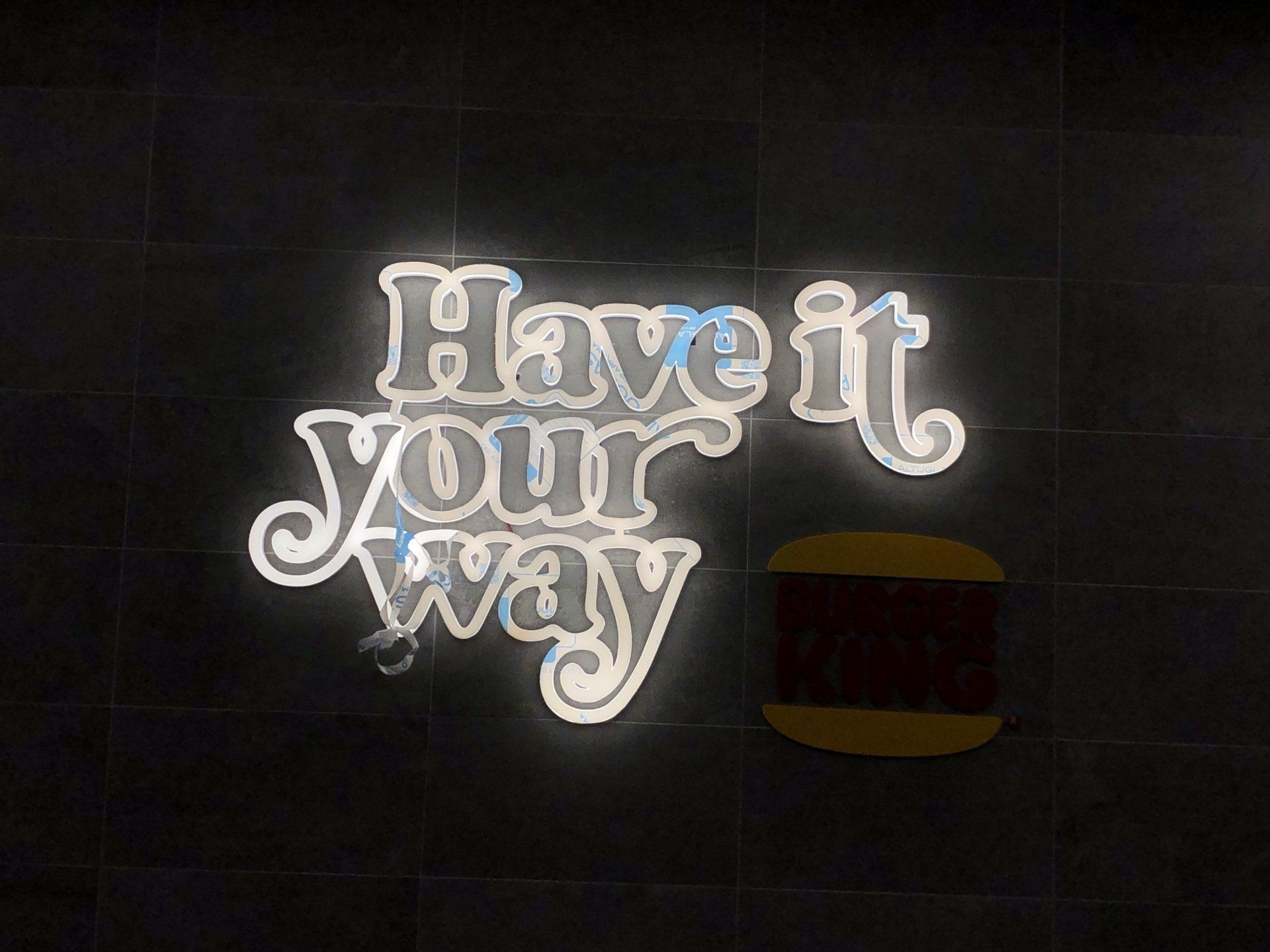 Cartello su un muro piastrellato nero con la scritta 