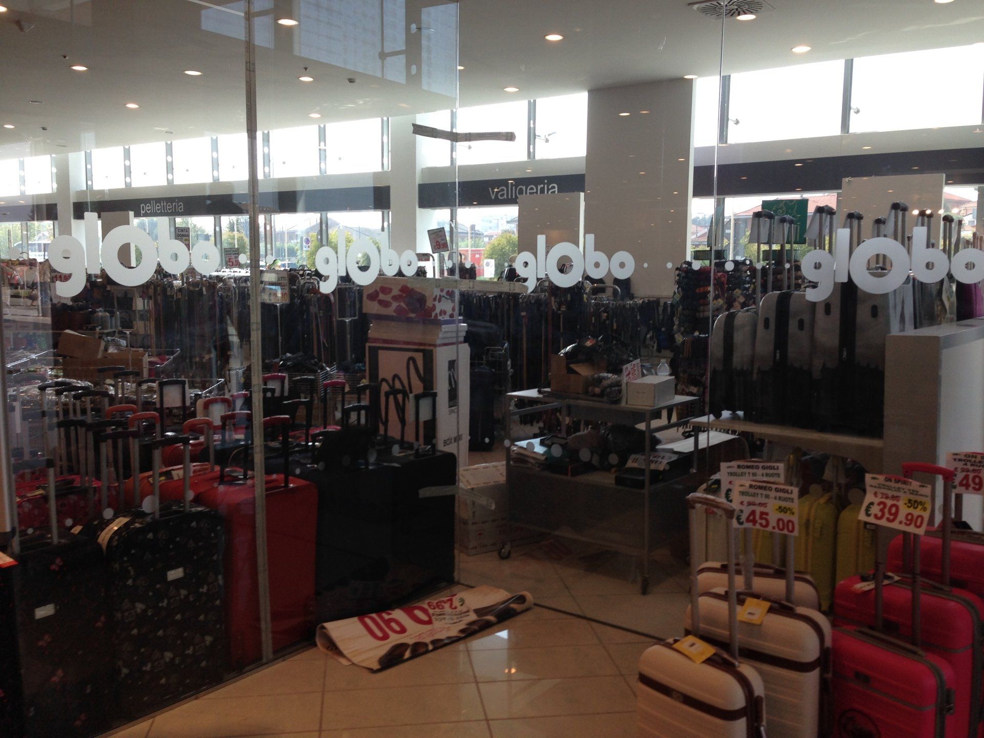 Interno del deposito bagagli con valigie in esposizione; logo 