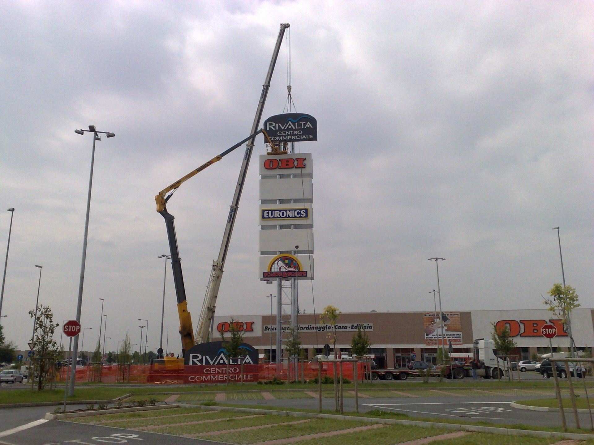 Una gru sta installando un'insegna per il centro commerciale