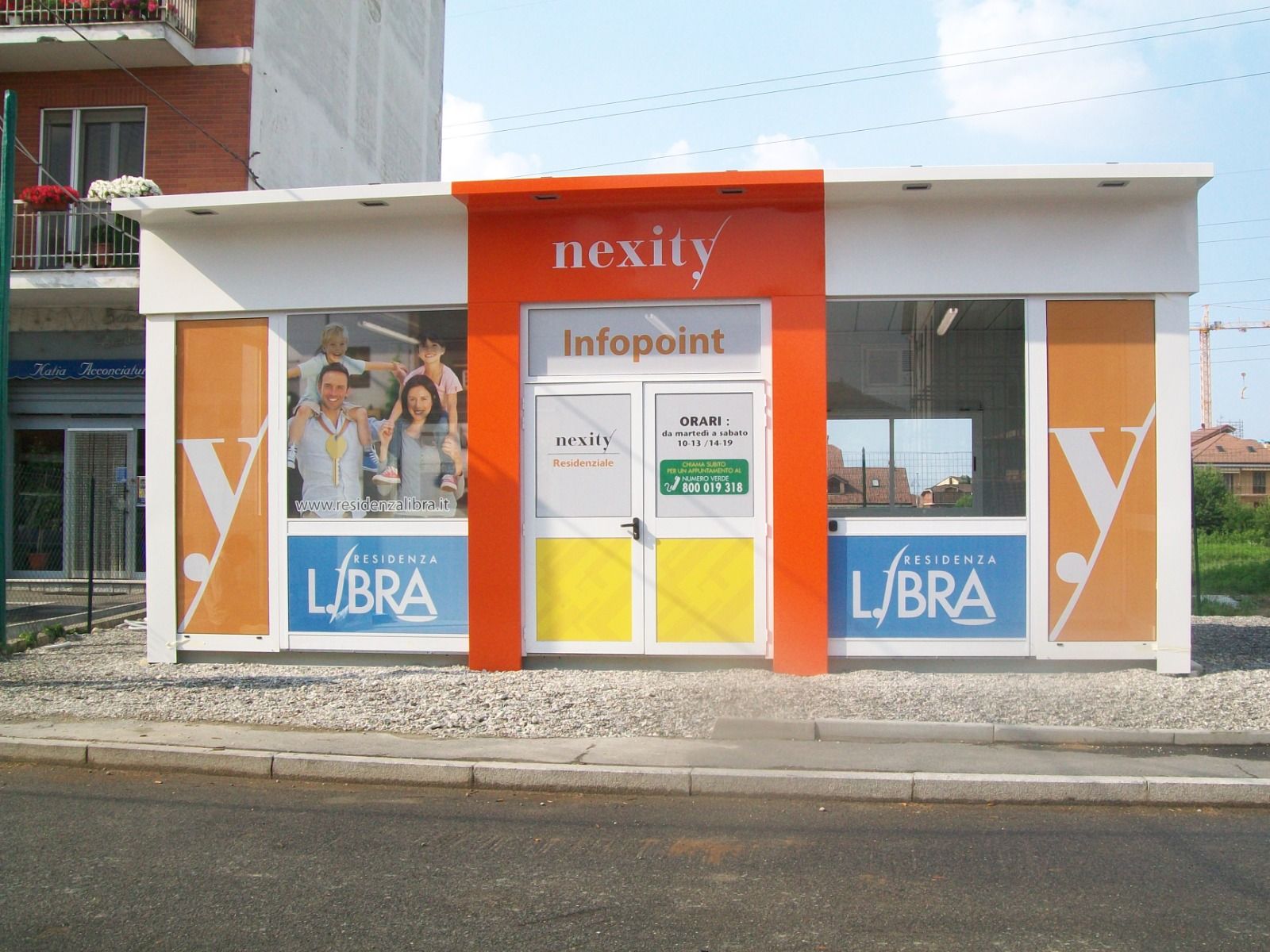 Chiosco Nexity Infopoint con dettagli arancioni e bianchi; marchio 