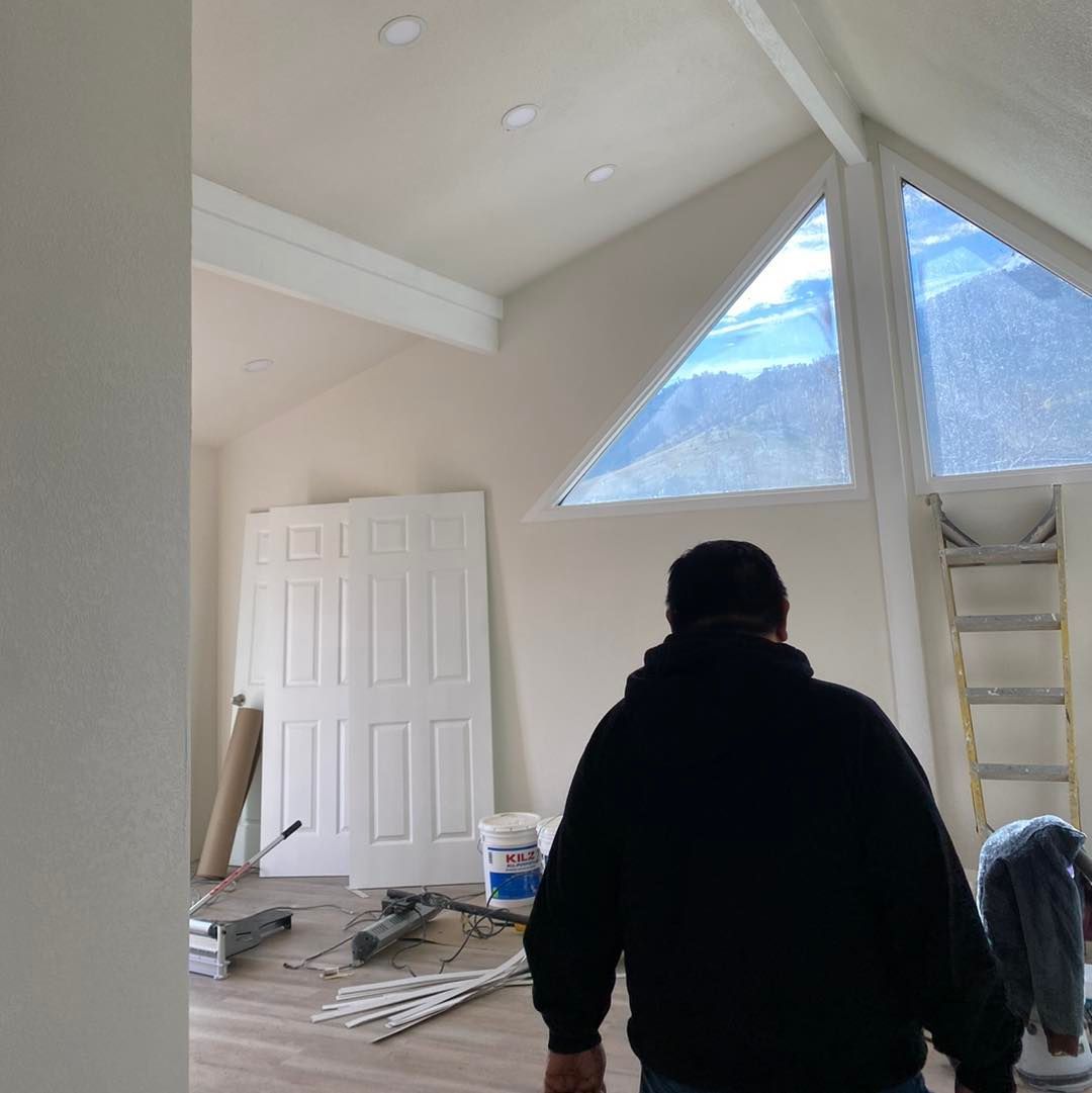 a man is standing in a room with a large window .