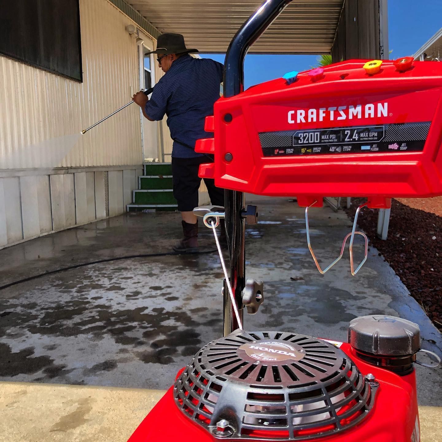 a red craftsman pressure washer is being used by a man